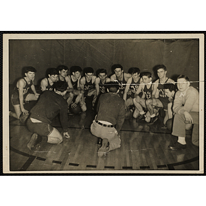 The Boys' Club Boston basketball team kneels down and takes instruction from its coaches