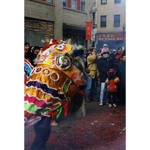 Men, women, and children observe the dragon dance in the street during a celebration of the Chinese New Year in Boston's Chinatown