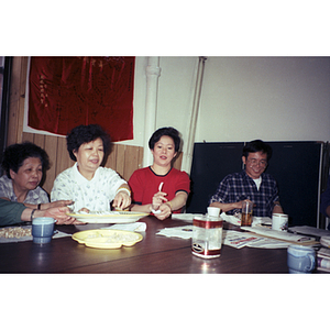 Association members pass around utensils at Suzanne Lee's birthday celebration