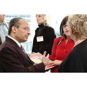 Mary Margaret Baker, '72, right, converses with other guests about the Northeastern Synthesis Research Magazine at the NU Today Cancer Research Panel luncheon