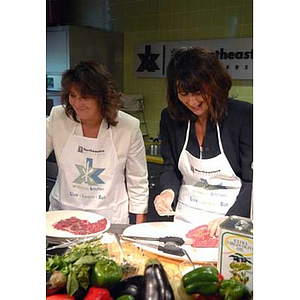 Two women cook when the Torch Scholars visit the Exhibition Kitchen