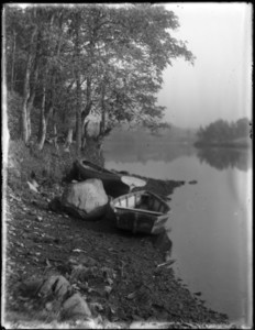 Rowboat and canoe on riverbank