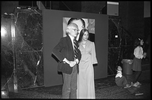 Andy Warhol and unidentified woman standing in front of his unveiled portrait of Charles Ireland at a reception at the Birmingham Museum of Art