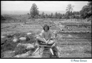 Peter Simon seated in a wheelbarrow in garden plot, Lama Foundation