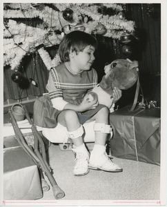Young girl with toy under Christmas tree