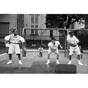 Three girls performing a dance in a playground.