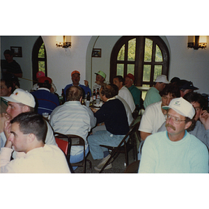 People seated around tables eat and converse at a Boys & Girls Club Golf Tournament