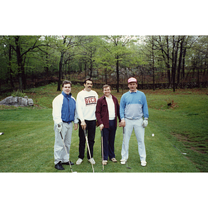 A four-man golf team posing on the golf course at a Boys & Girls Club Golf Tournament