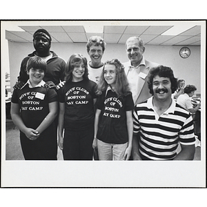 Four men, including John M. Durkin, at far left, posing with a girl and two boys wearing Boys' Clubs of Boston Day Camp t-shirts at a Boys' Club's event with New England Patriots