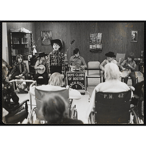 A group of boys perform for an elderly audience