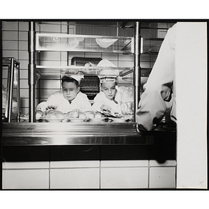 Two members of the Tom Pappas Chefs' Club put out bread in a Howard Jonson's cafeteria line