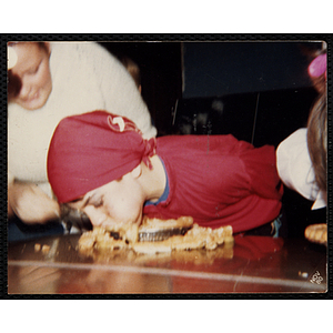 A boy participates in a pie eating contest at a Halloween party