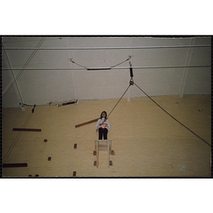 A girl stands on top of a platform in a gymnasium