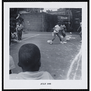 Two boys with balloons tied to their ankles play a game during Tom Sawyer Day