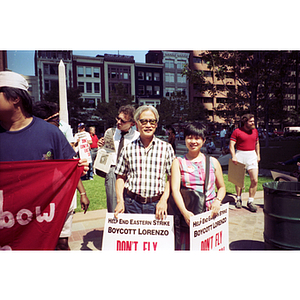 Two Asian Americans participate in a demonstration in Boston and holding protest signs