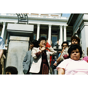 Woman speaks from the steps of the Massachusetts State House at a rally for bilingual education in schools