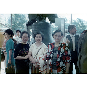 Three women pose in front of the Liberty Bell in Philadelphia, Pennsylvania