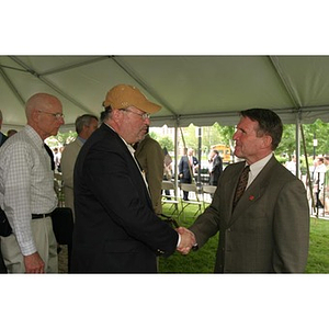Two men shake hands at the Veterans Memorial groundbreaking ceremony