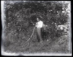 Young man sharpening a scythe