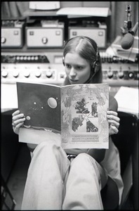 Unidentified woman reading Free Spirit Press magazine in radio broadcast studio
