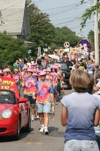 Paraders in tie-dyed shirts and pink hats : Provincetown Carnival parade