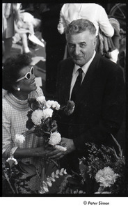 Robert Kennedy and Kenneth Keating campaigning in Riverdale: Andrea Simon holding flower bouquet with unidentified man