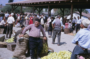 Leaning on green peppers at Ohrid market