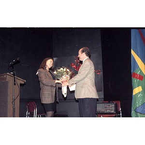 David Cortiella presents flowers to an unidentified woman on stage.