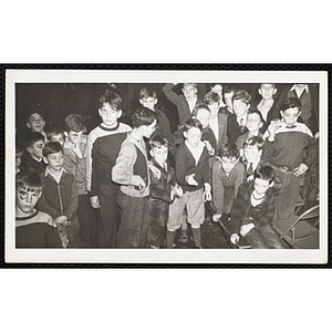 A group of Boys' Club members sit and stand with painted faces