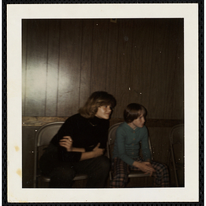 A woman and a boy from the South Boston Boys' Club sitting in chairs and looking off to their left