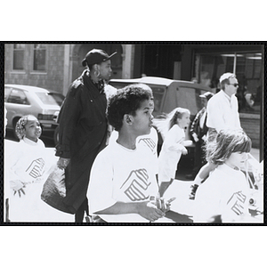 Several boys and girls wearing Boys and Girls Clubs of Boston t-shirts, walking down the street during the Boys and Girls Clubs of Boston 100th Anniversary Celebration Parade