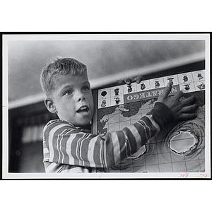A boy holds up a Stratego board