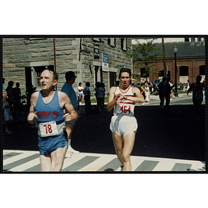 A man and a woman cross the finish line of the Battle of Bunker Hill Road Race