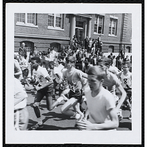 A pack of runners pass spectators during the Roxbury Road Race