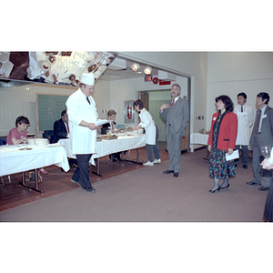 Charlene Tse listens as a chef addresses the crowd at a food tasting event