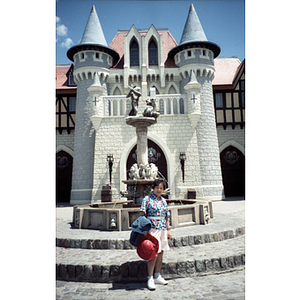 Woman poses in front of a fountain in an amusement park
