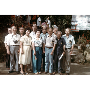 Men and women stand for a group photograph outdoors