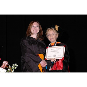 Dean Carole Kenner presents Molly Katherine Clancy with an award for Academic Excellence at the School of Nursing convocation