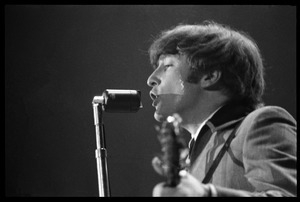 John Lennon at the microphone, in concert with the Beatles, Washington Coliseum