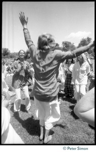 Bhagavan Das raising his arms with dancing women during Ram Dass's appearance at Sonoma State University