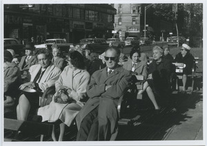 People sitting on benches at the intersection of West 86th Street and Broadway in New York City