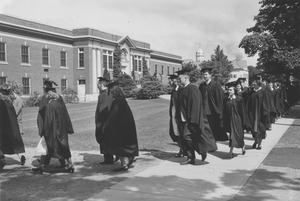 Graduates in a commencement procession outside Curry Hicks Cage