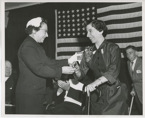 Unidentified woman handing gift to client at Institute Day