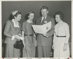 Willis C. Gorthy and three women read a large pamphlet