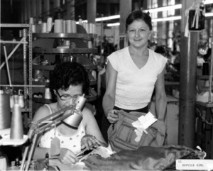 Photograph of two women handling cloth and a bag, [1982-1983].
