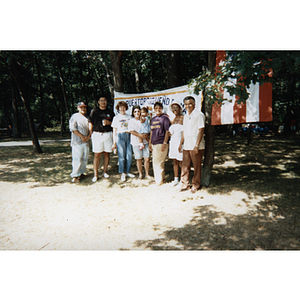 Carmen Pola and several others stand in front of a Festival Puertorriqueño banner at a picnic event