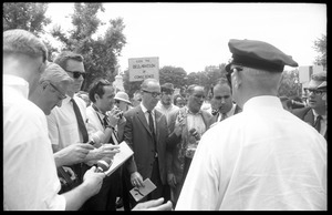 David Dellinger (center) being interviewed by the press after the Assembly of Unrepresented People peace march was attacked with red paint by right wing counterprotesters