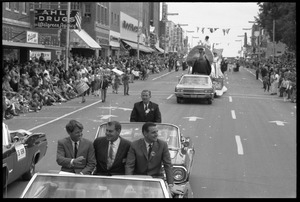 Robert F. Kennedy (left) and Walter Mondale (right) riding in an open car at the Turkey Day parade while stumping for Democratic candidates in the northern Midwest