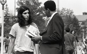 Bill Grabin showing Free Spirit Press magazine to African American faculty member in front of the UMass Amherst Student Union