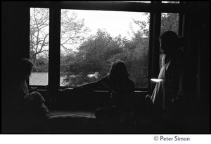 Vicente Street houses members, seated on a sofa silhouetted against a window